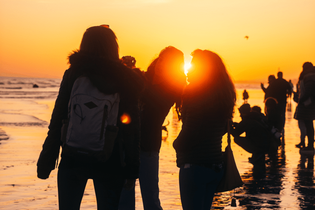 Silhouetted figures enjoying Brighton beach at sunset