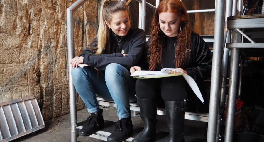 Two MetFilm School students sitting down reading a script.