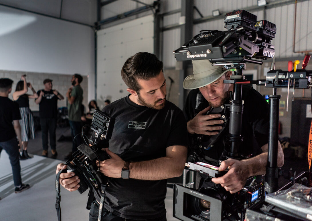 two filmmakers looking at camera equipment