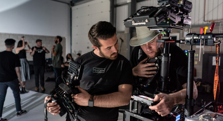 two filmmakers looking at camera equipment