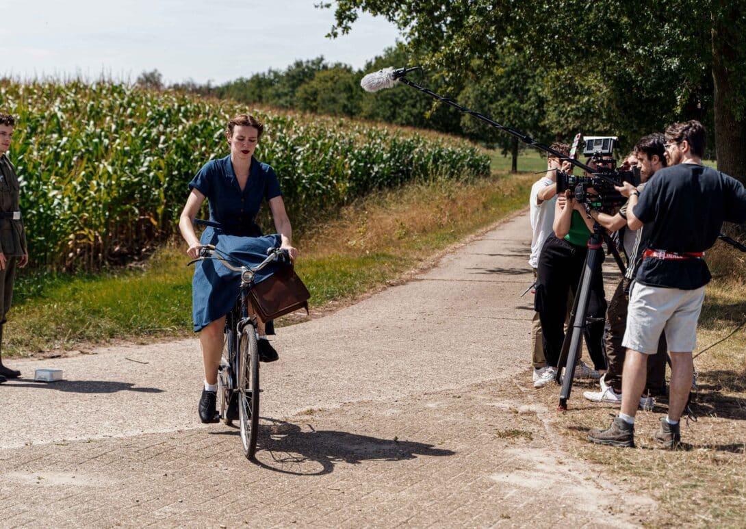 Actors near pathway by a crop field filming
