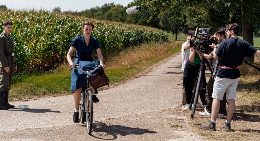 Actors near pathway by a crop field filming