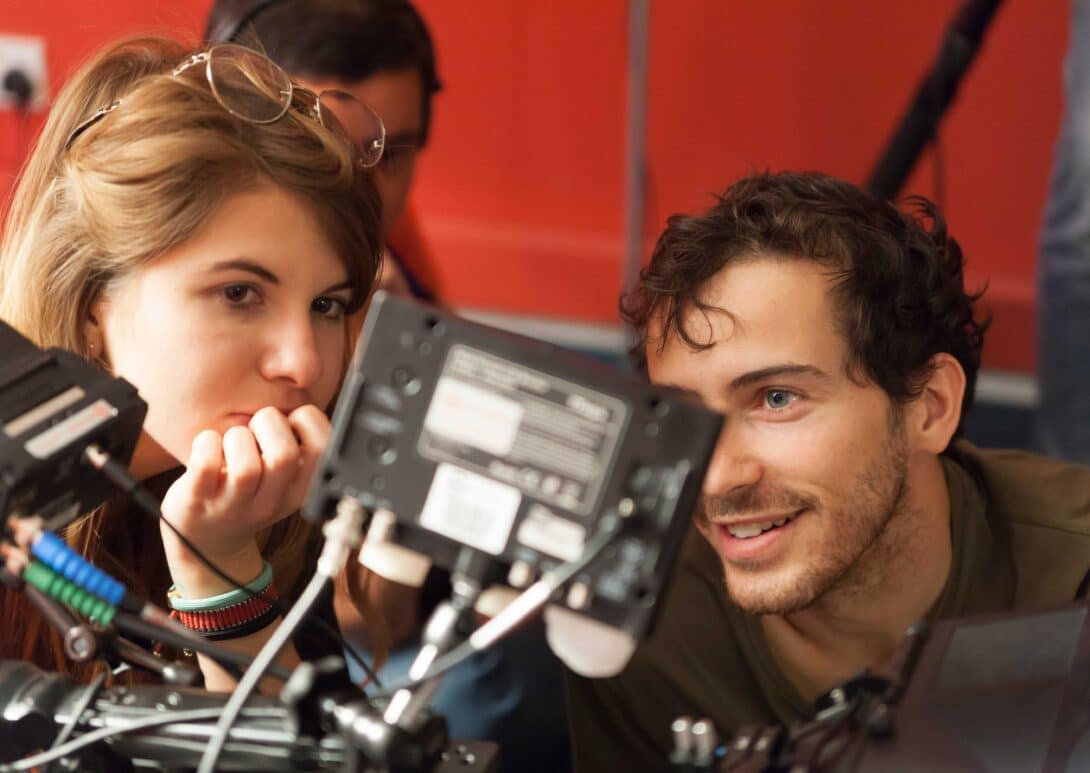 Two people examining a cinematography camera