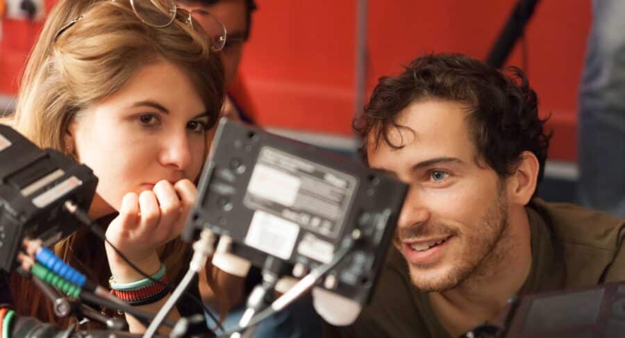 Two people examining a cinematography camera