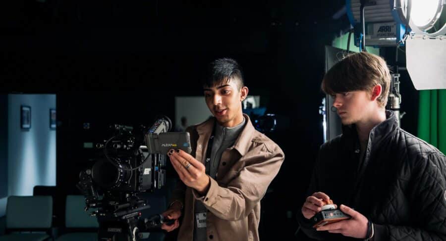 Two Manchester students adjusting film camera while on set