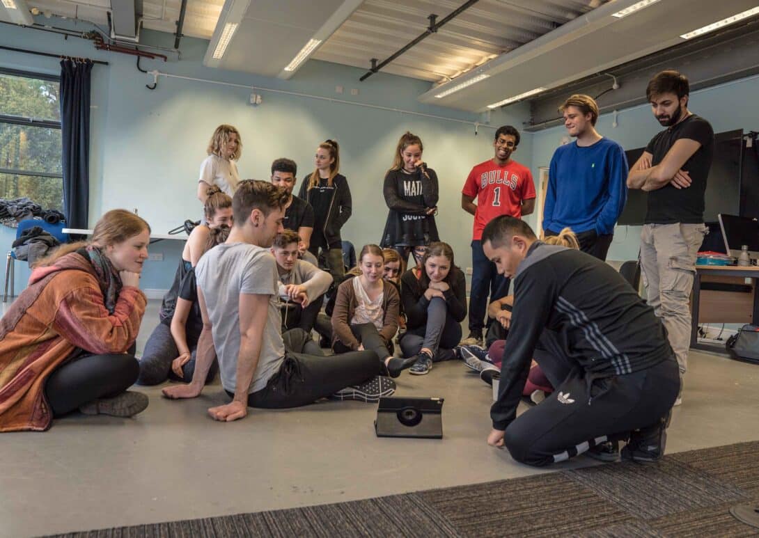 Many students huddled round a small tablet on the ground